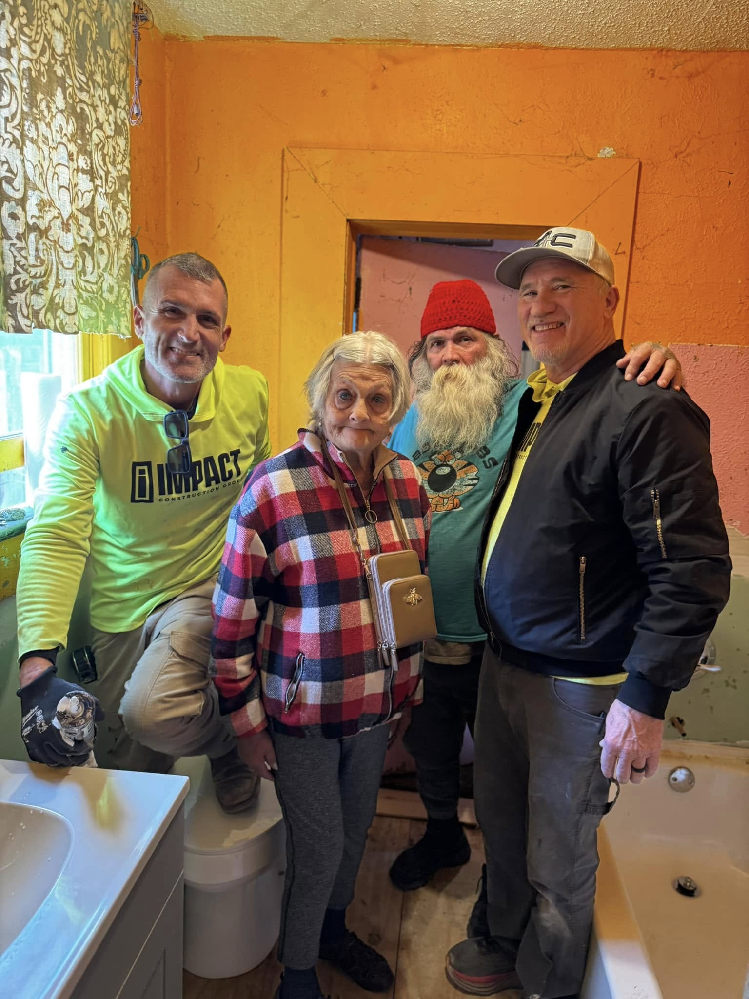 Volunteer team and plumbers inside the renovated bathroom